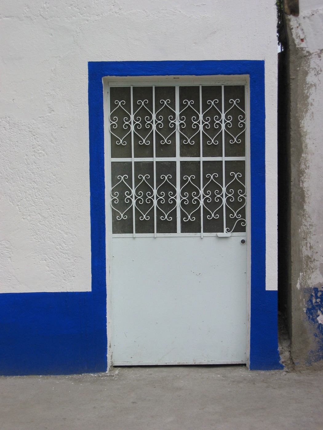 Whitewashed facade with a doorway framed in deep ultramarine blue